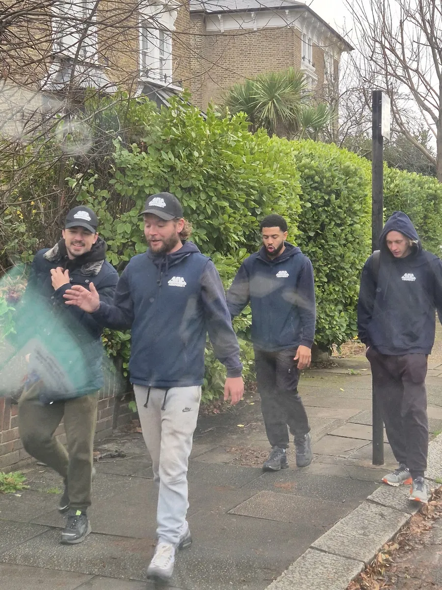 Four crew members walking to a job with kit