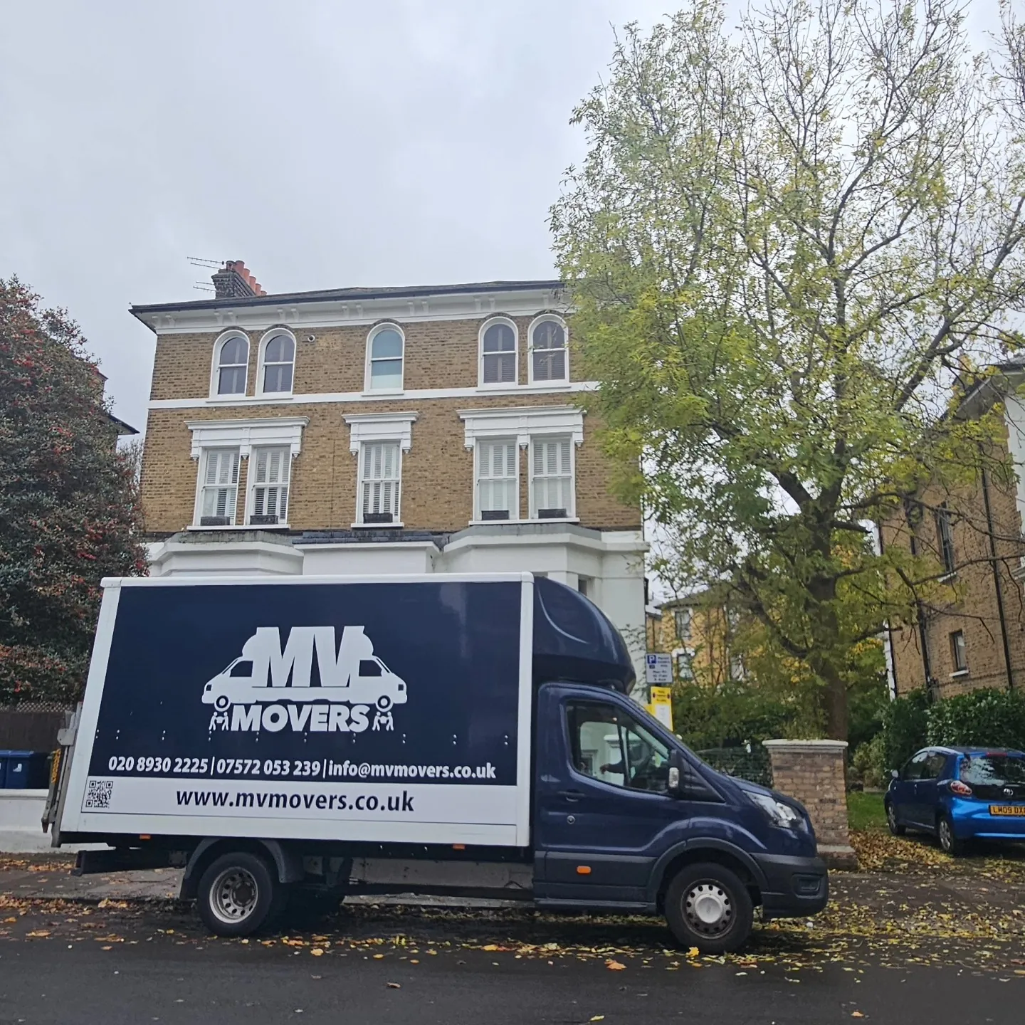 MV Movers van outside a large house