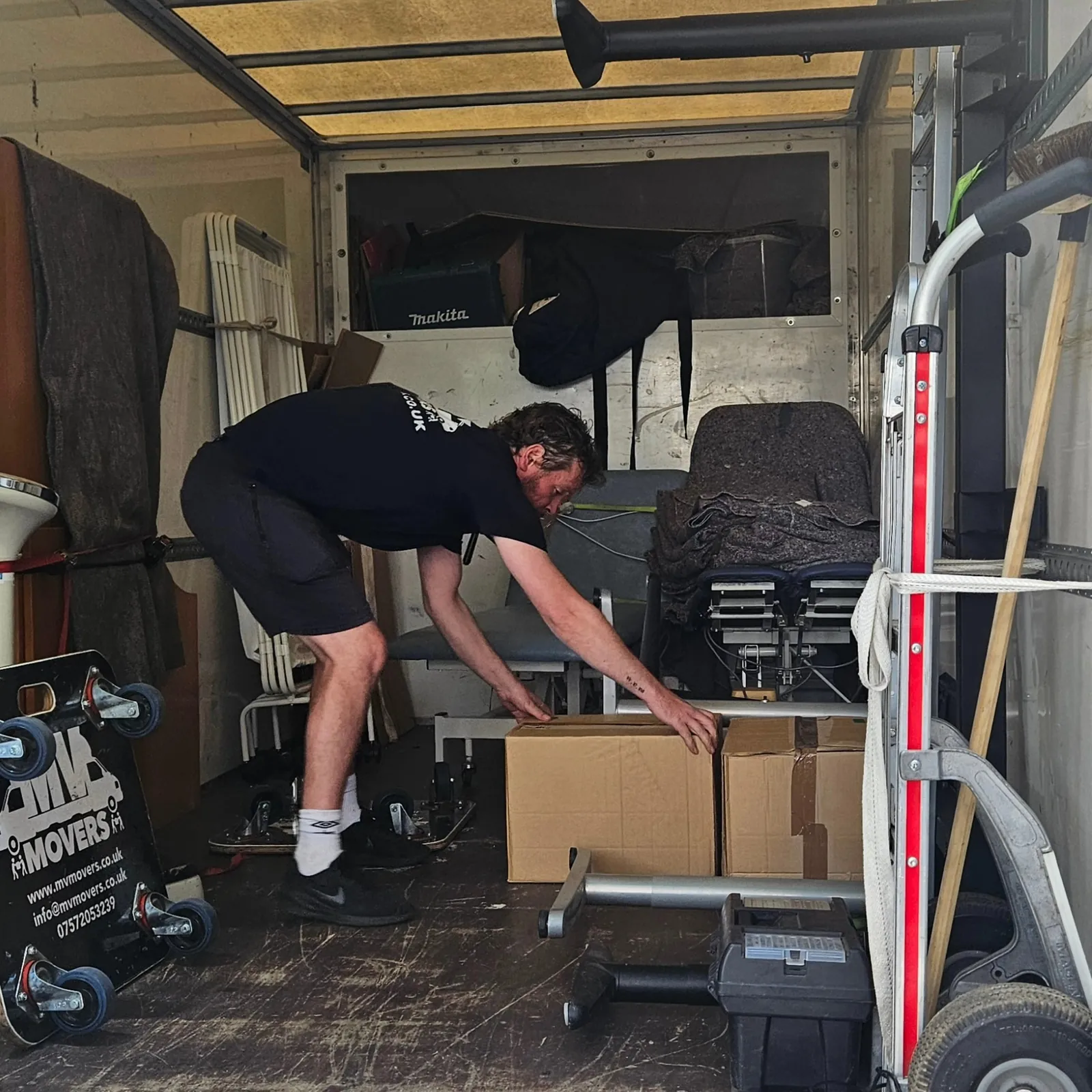 Inside an MV Movers van being loaded, blankets and straps in place